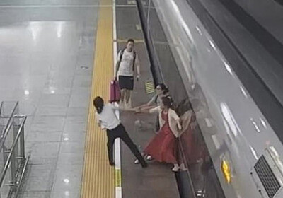 Опаздывая на работу: Отчаянная женщина попыталась ногой остановить скоростной поезд (Видео)
